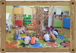 Dzieci układają drzewa na kolorowych kartonach.